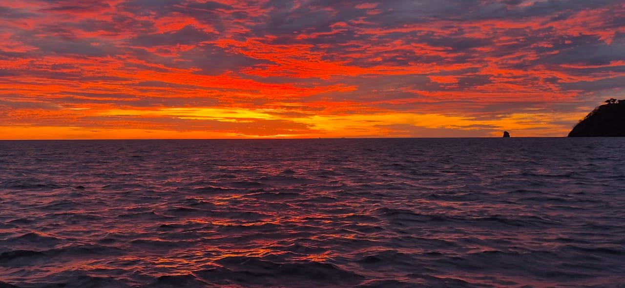 Atardecer de tonos naranja y rojo sobre el océano Pacífico